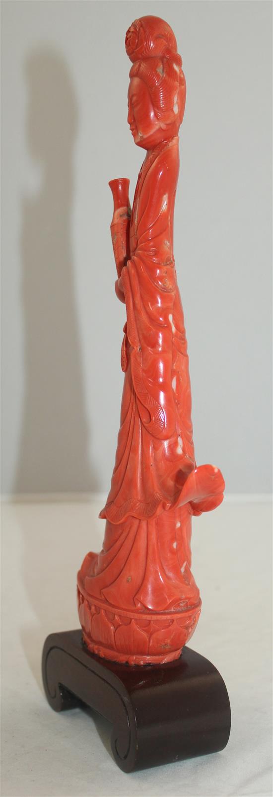 A large Chinese coral figure of Guanyin, 27.7cm incl. wood stand
